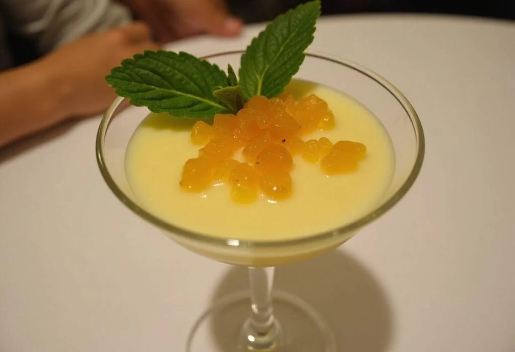 Mousse de Maracujá finalizada e decorada com polpa de maracujá e folhas de hortelã.