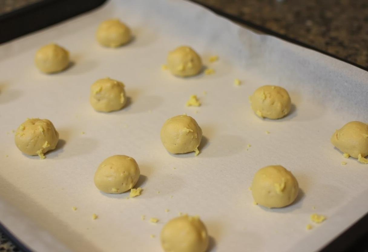Pão de Queijo dough balls on a baking sheet before baking.