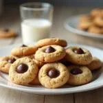 Cookies com chocolate MMs prontos para serem servidos, perfeitos para acompanhar um copo de leite.