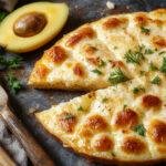 Prato de gratinado de atum apresentado em uma travessa branca, com camada dourada e crocante de queijo por cima, pedaços visíveis de batata e atum, decorado com salsa fresca, tudo em um ambiente bem iluminado e apetitoso.